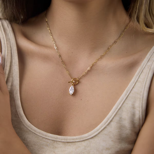 gold necklace with marquise gemstone pendant pictured worn around a neck