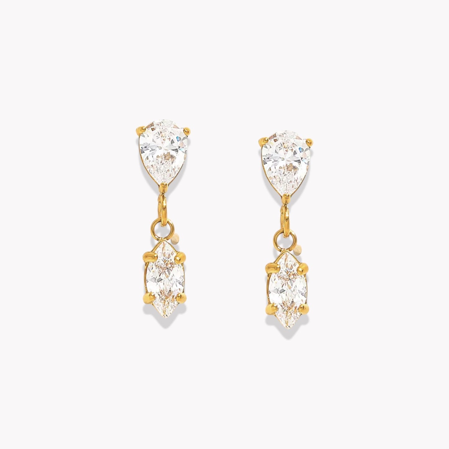 Gold earrings with clear gemstones on a white background
