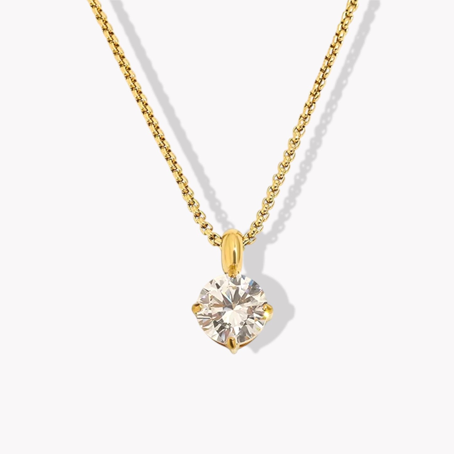 Gold round shaped diamond necklace on a white background