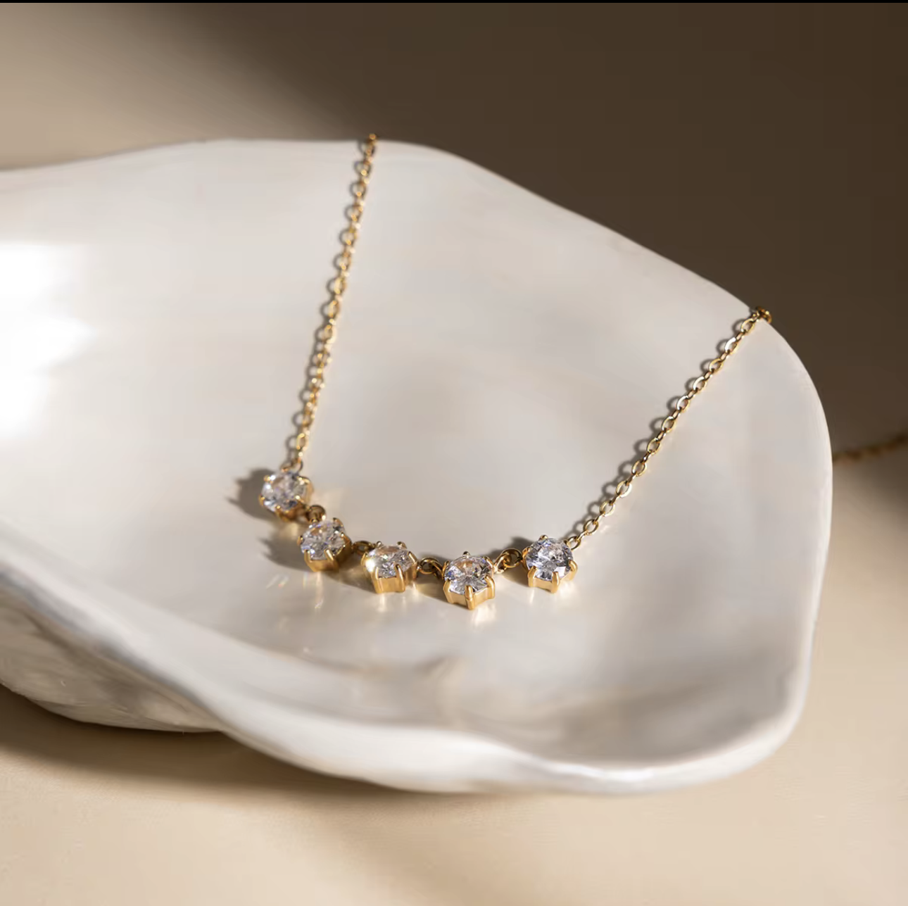 Gold necklace with diamonds on a white shell