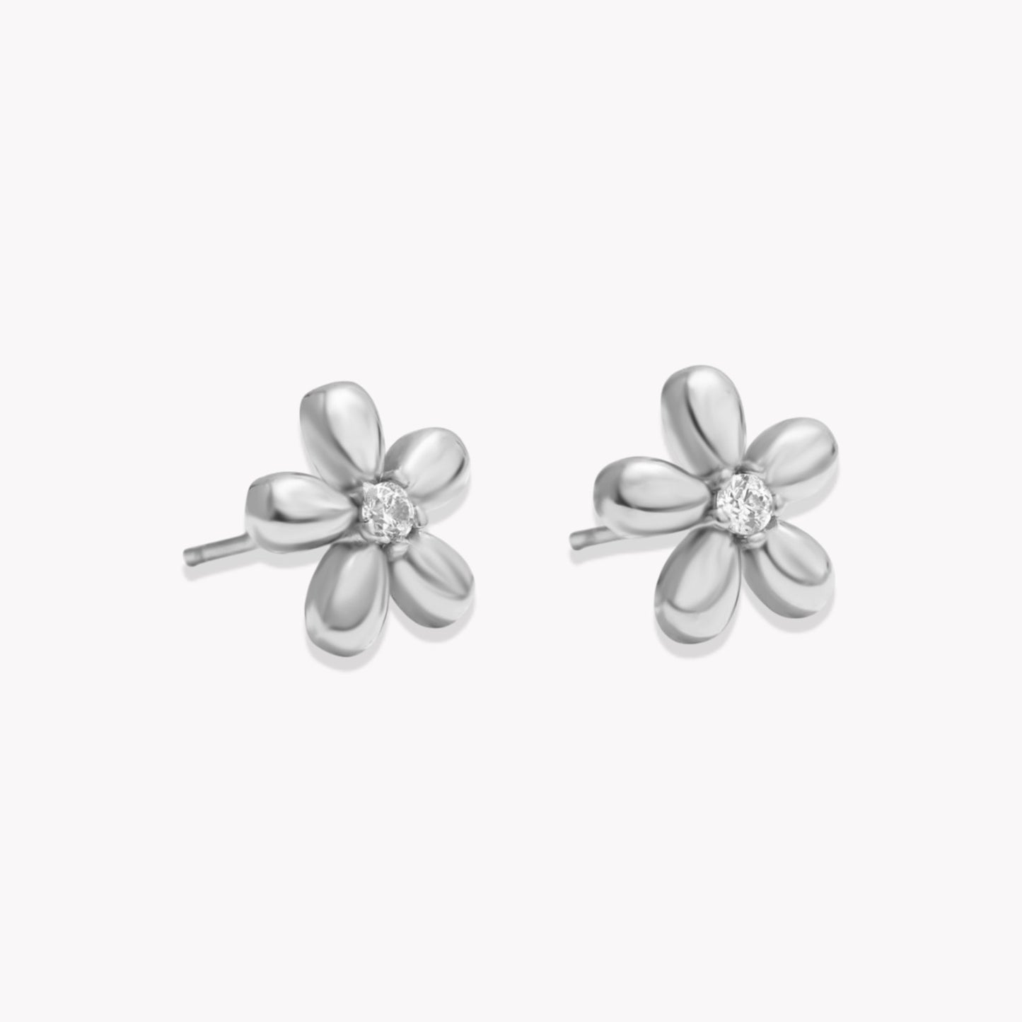 A pair of silver stud earrings designed to resemble flowers with a central gemstone in the center.