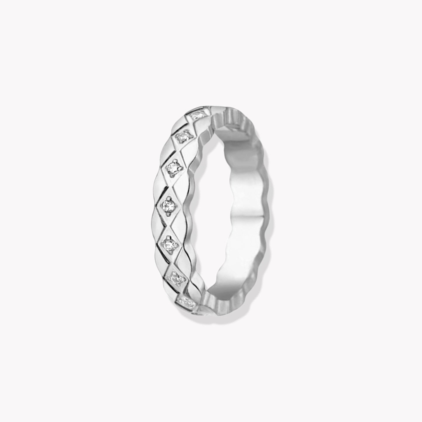 A silver ring with gemstone details, featuring a band design.