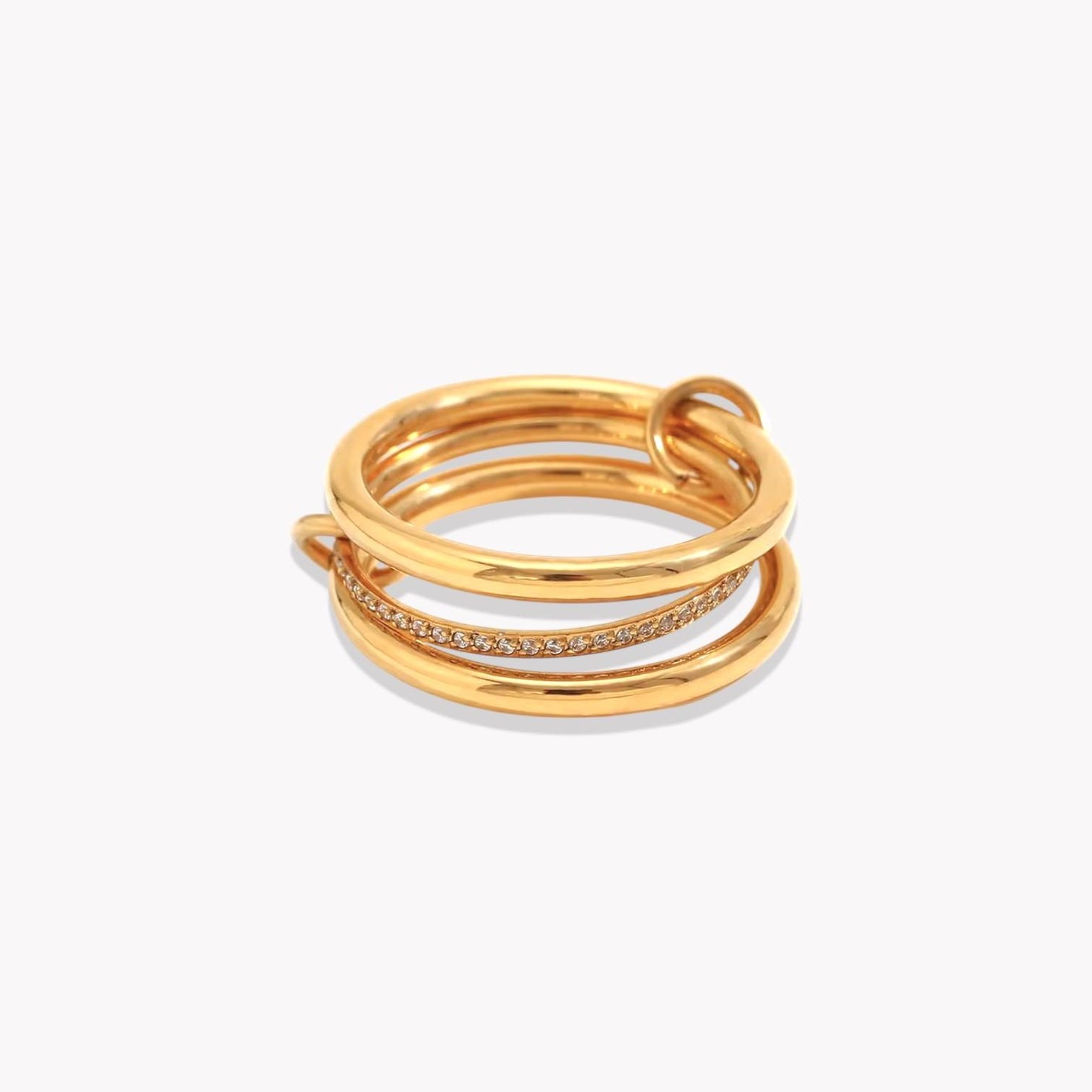 Set of three rings, two plain with the third thinner band in the middle with gemstones. All three rings are linked together with smaller loops. Pictured on a white background