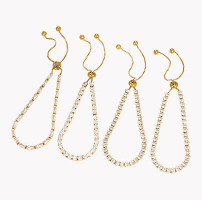 Four gold-tone drop earrings with clear rhinestone-studded teardrop-shaped chains, arranged in a row against a plain white background.