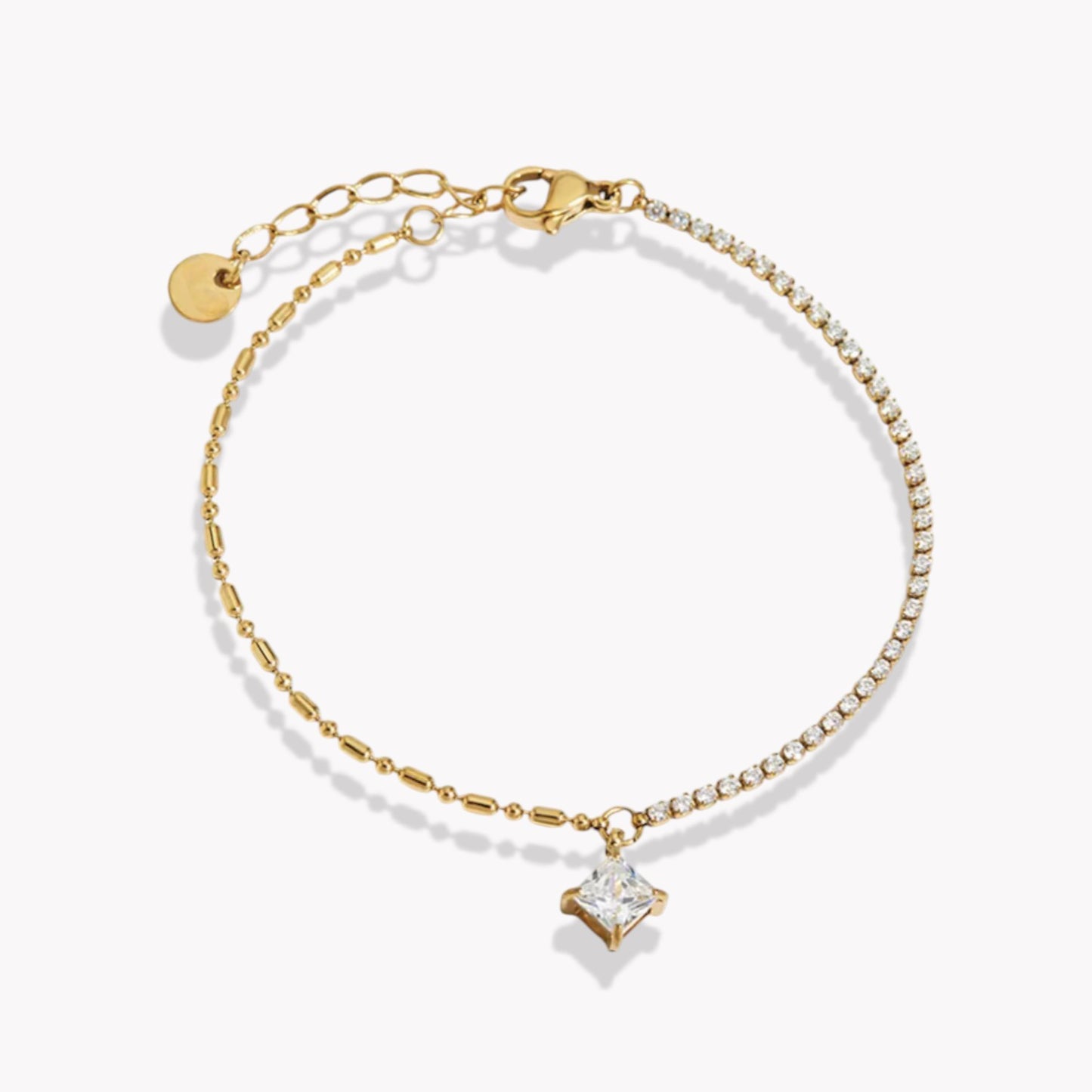 Gold bracelet with a square cut crystal charm on a white background