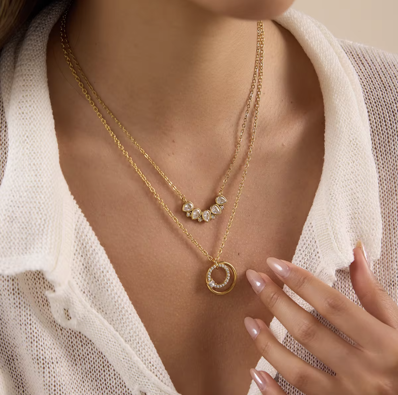 Close up of a gold necklace with circular pendant being worn