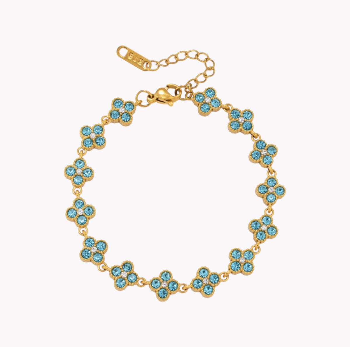 A gold-tone bracelet featuring repeating four-petal flower motifs set with light blue rhinestones, shown on a plain white background.