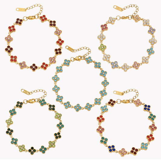 Five gold-tone floral link bracelets with colorful enamel clover motifs, arranged on a plain white background.