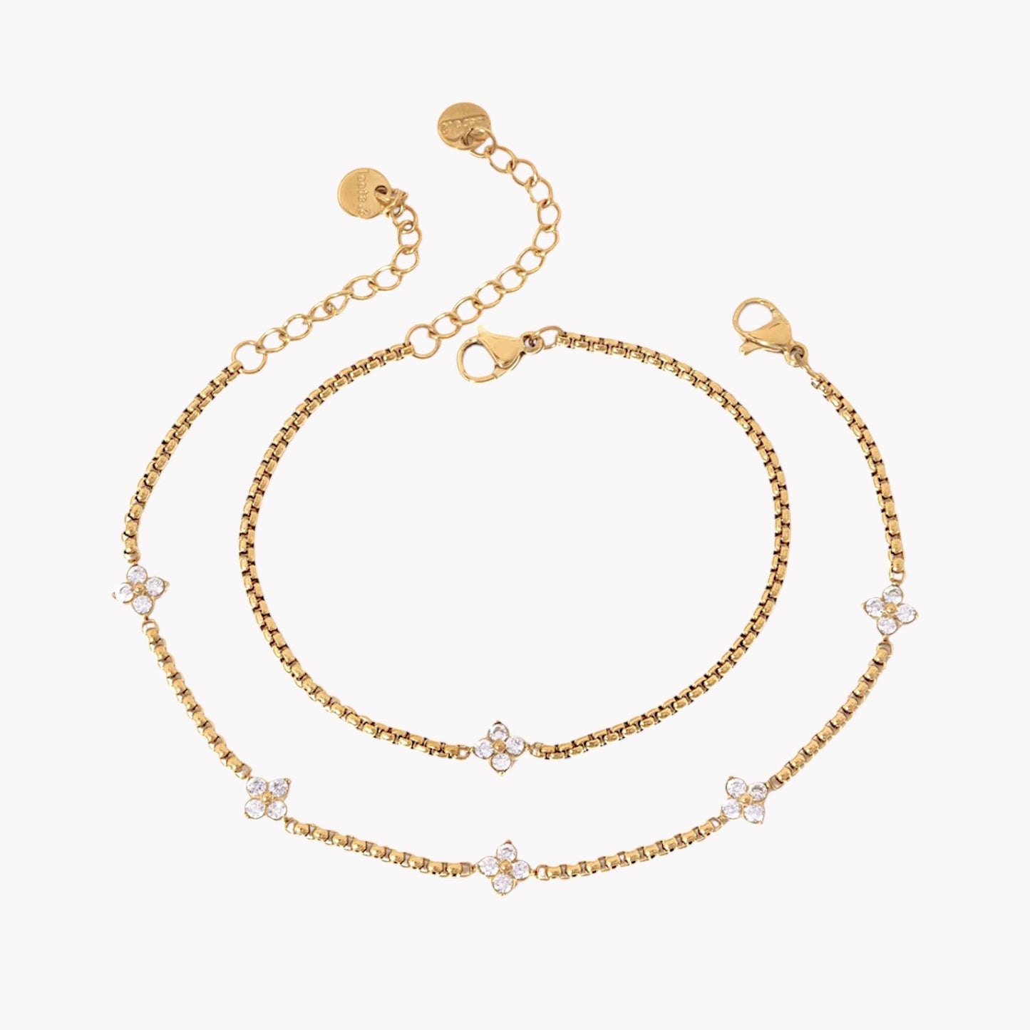 Gold bracelet with floral-shaped charms on a white background