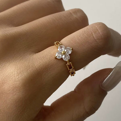 Ring featuring floral gemstone detail being worn on a finger