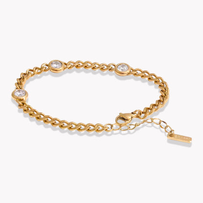Gold chain bracelet with 3 embedded stones on a white background
