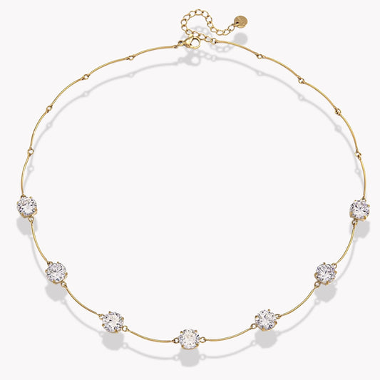 gold necklace with 7 beautiful gemstones on light grey background