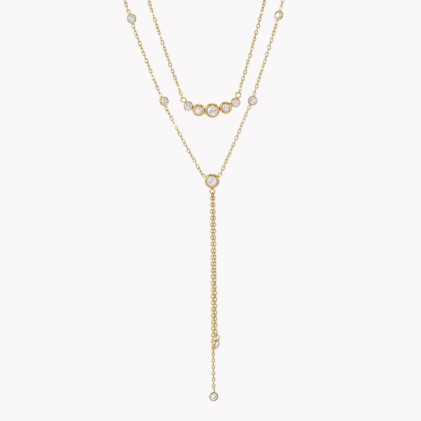 gold double layered necklace with clear gemstones pictured on a light grey background