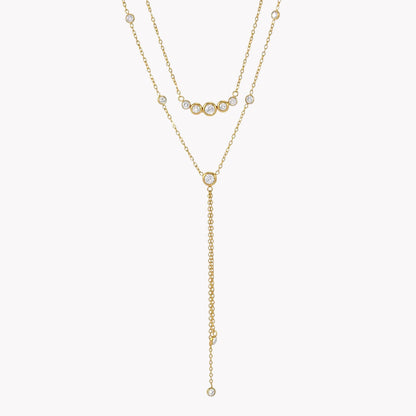 gold double layered necklace with clear gemstones pictured on a light grey background