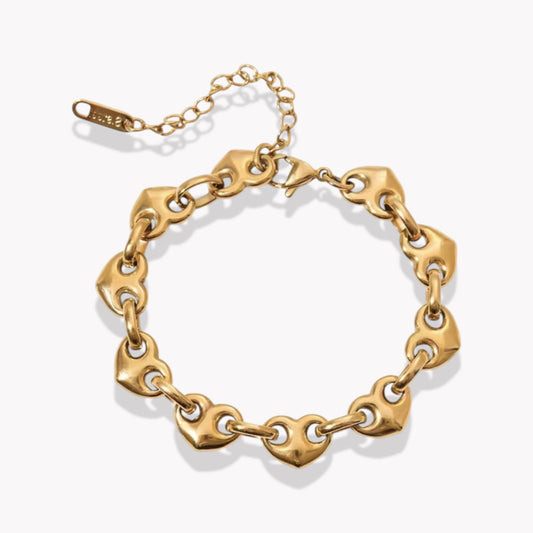 Gold chunky chain bracelet with heart chaped links on a white background
