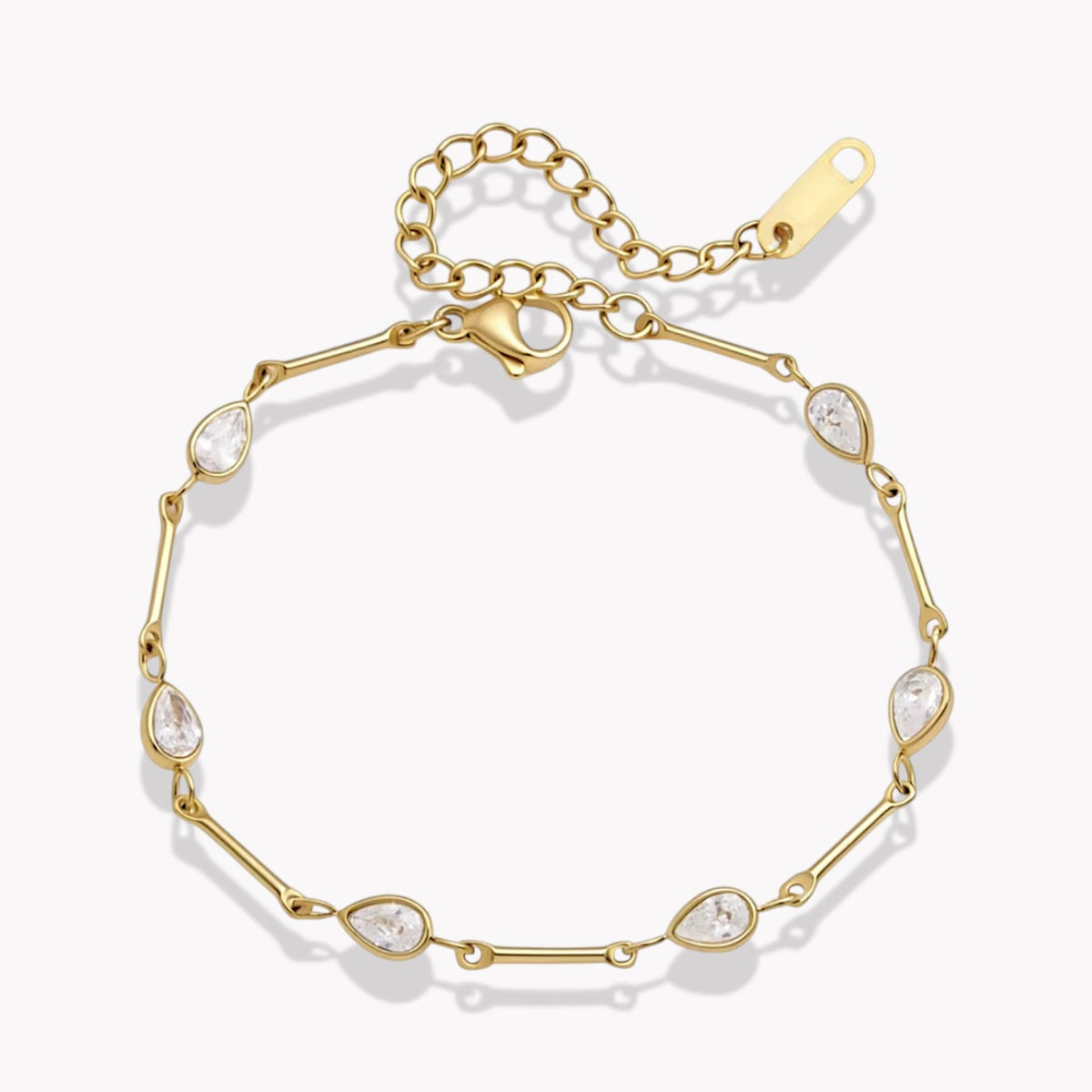 A gold chain bracelet with eight teardrop-shaped clear crystals spaced along the link chain, shown on a clean white background.