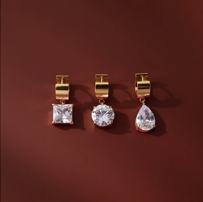 numerous gold earrings with gemstones on a red background