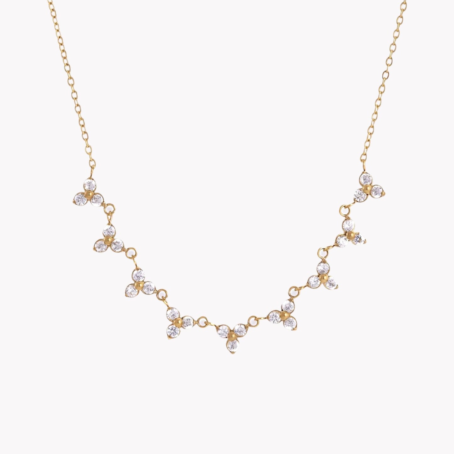 Gold necklace with floral designs on a white background