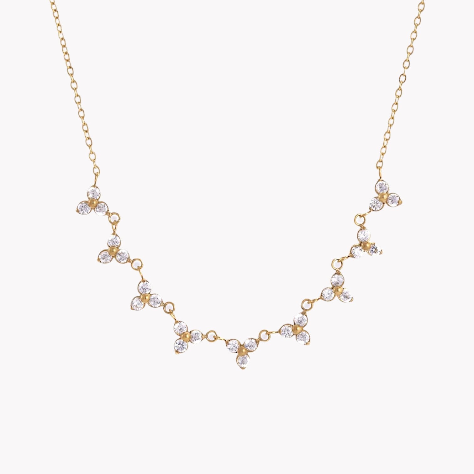 Gold necklace with floral designs on a white background