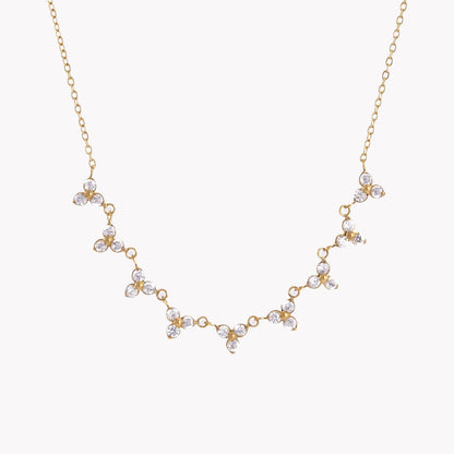 Gold necklace with floral designs on a white background