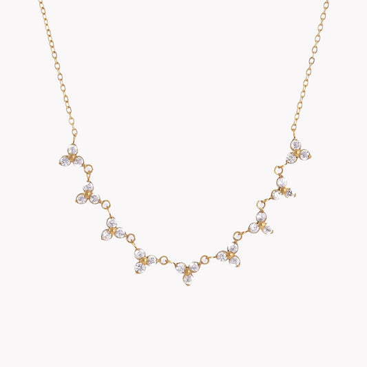 Gold necklace with floral designs on a white background