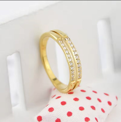 A gold-colored double layer ring with small embedded stones shown on a neutral background