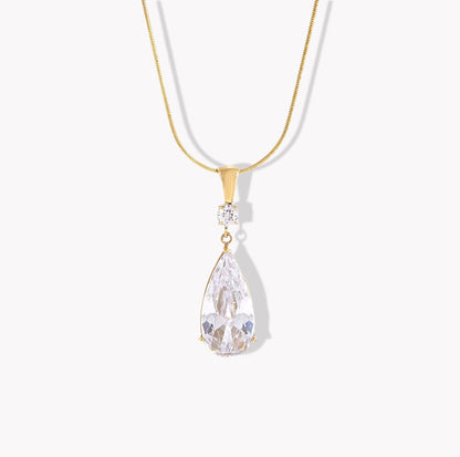Gold necklace with a teardrop-shaped crystal pendant on a white background