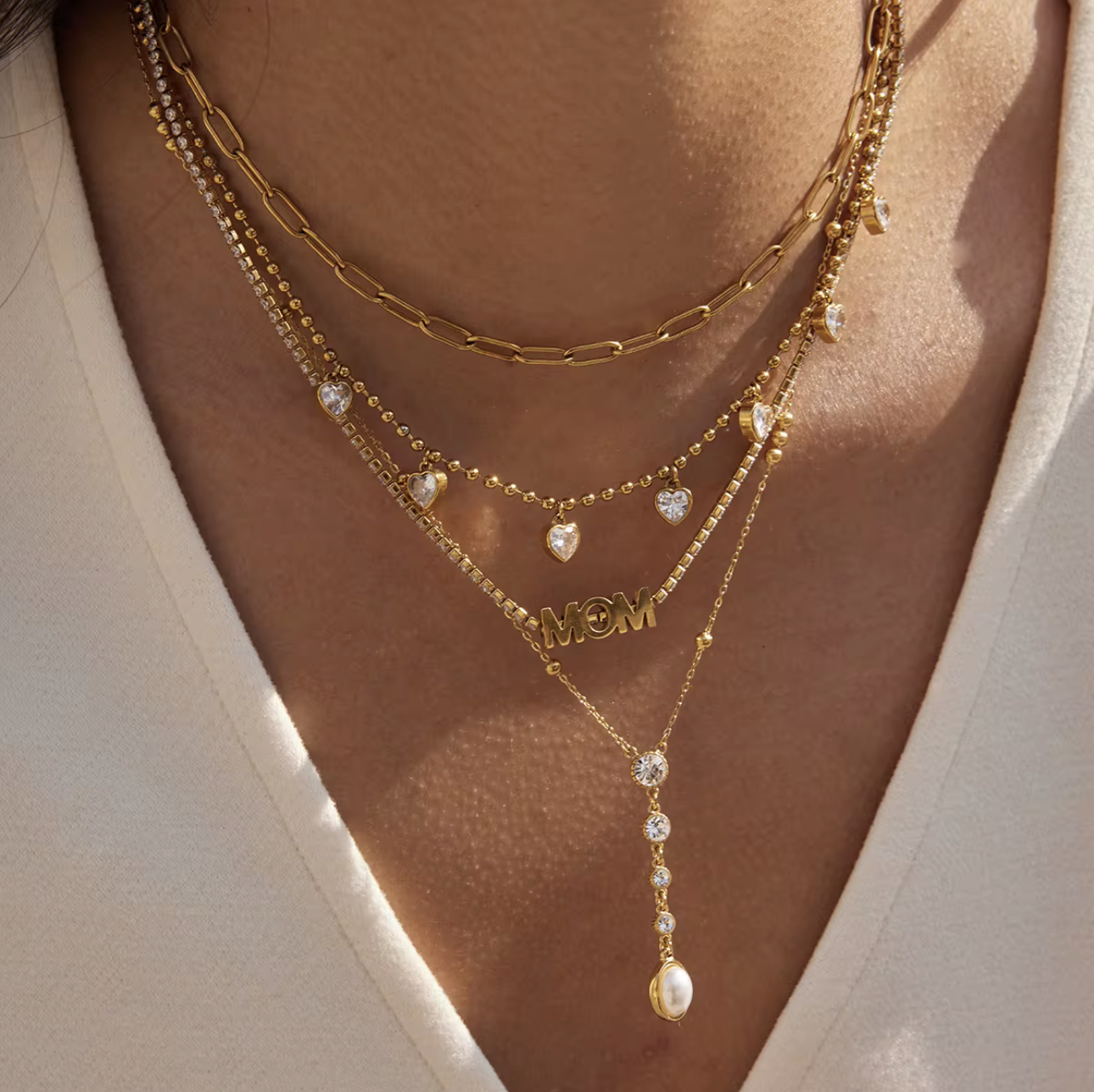 close up of gold necklaces being worn around a neck