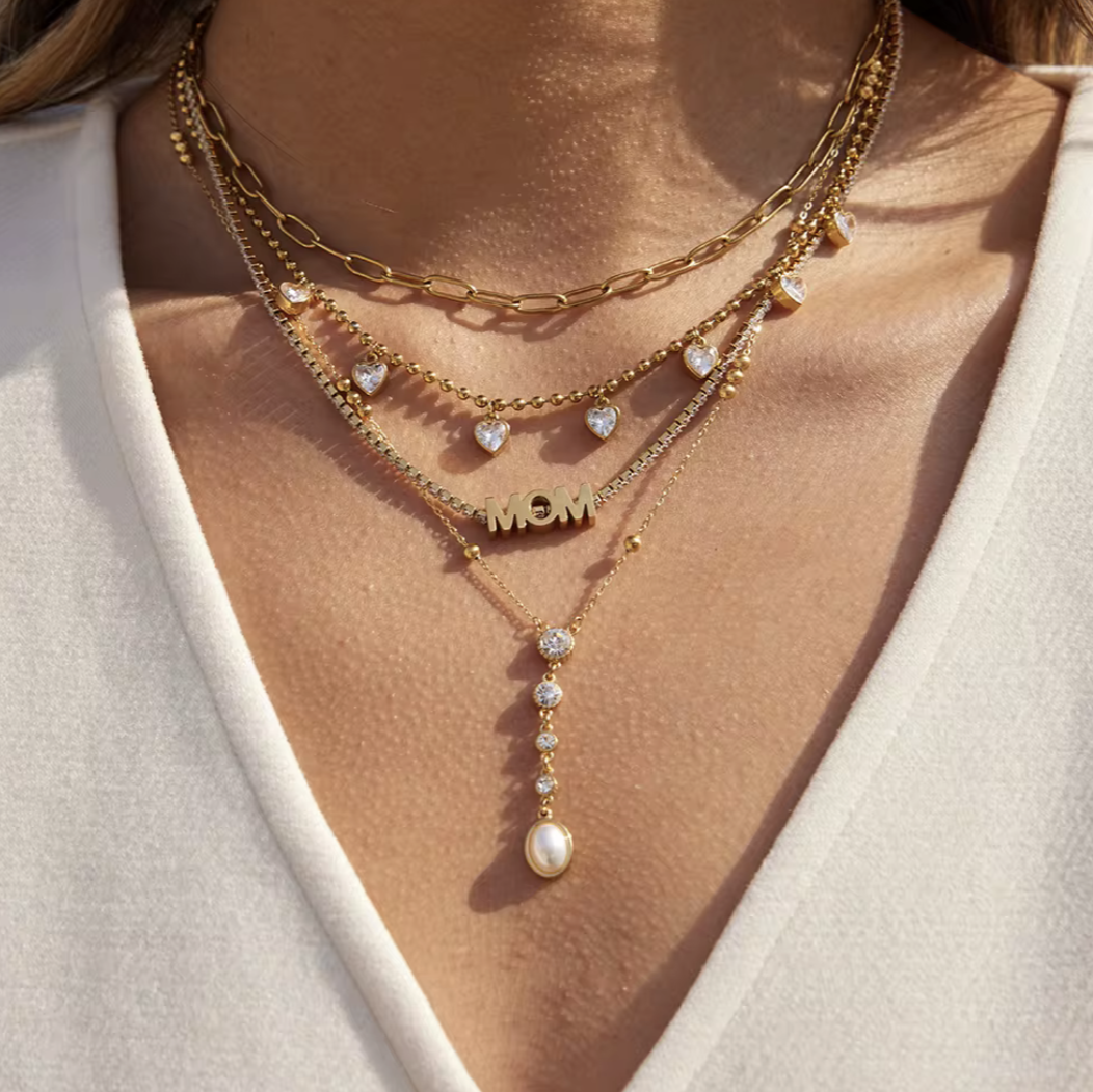 close up of gold necklaces being worn around a neck