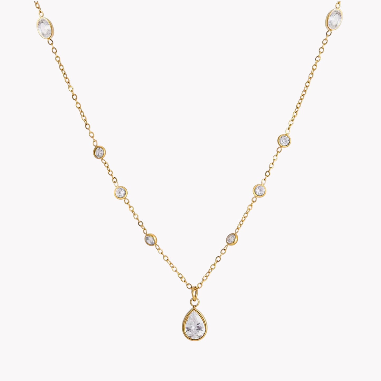 Gold necklace with a teardrop-shaped pendant on a white background