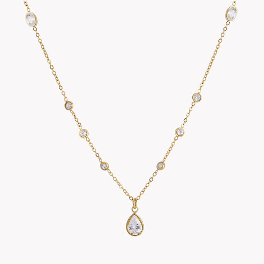 Gold necklace with a teardrop-shaped pendant on a white background