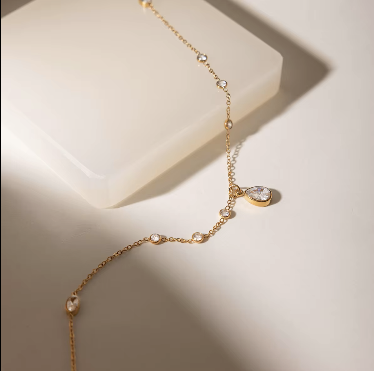 Gold bracelet with heart-shaped charms on a light background