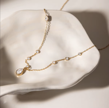 Delicate gold necklace with small diamonds on a white shell