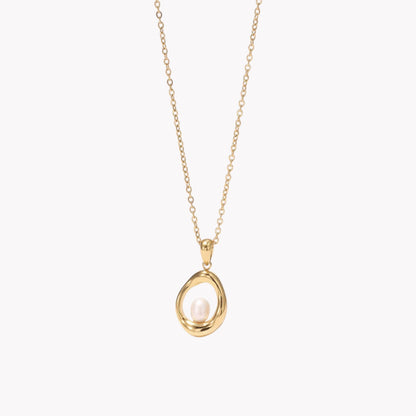 gold necklace with circular pendant featuring a small pearl inside
