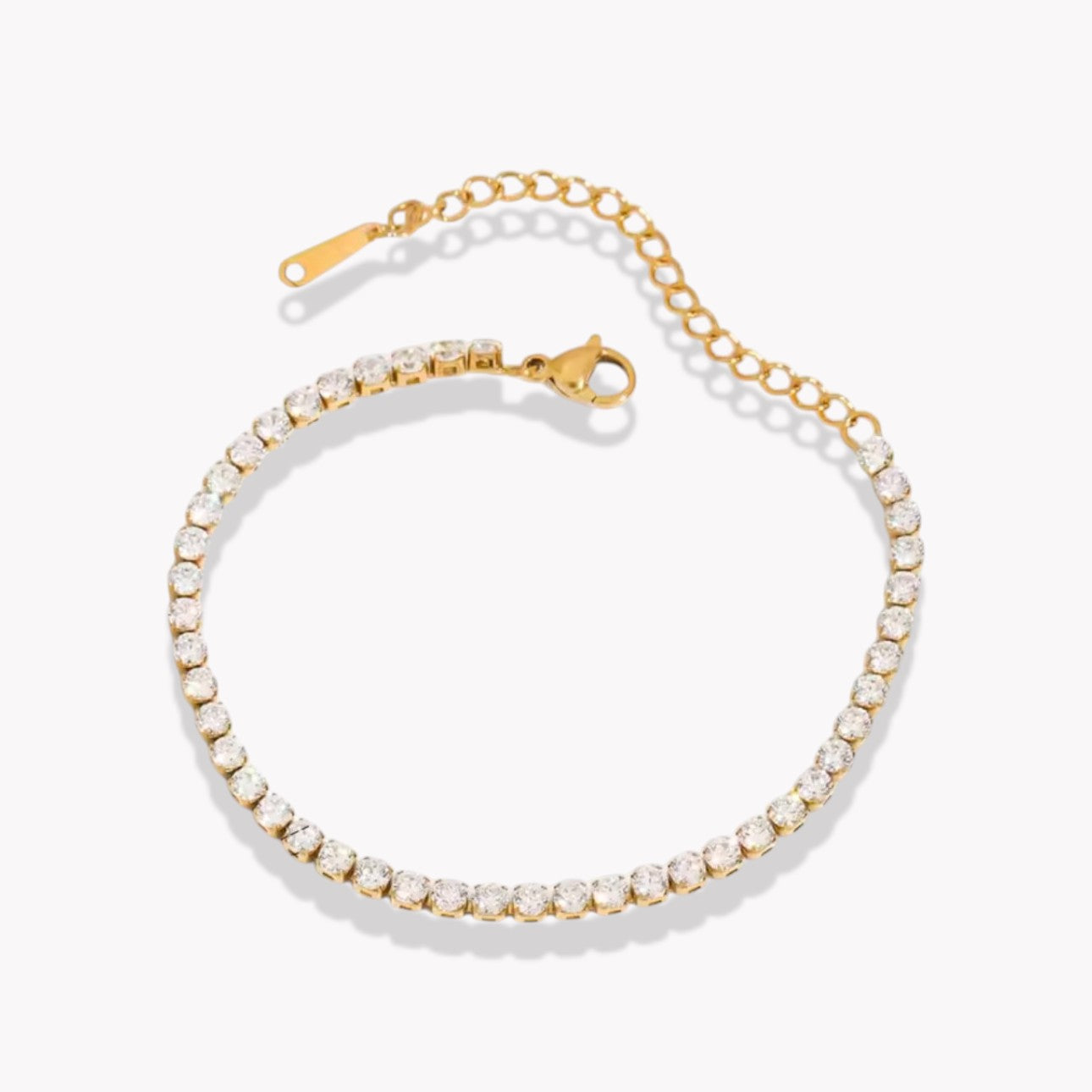 Gold bracelet with white stones on a grey background