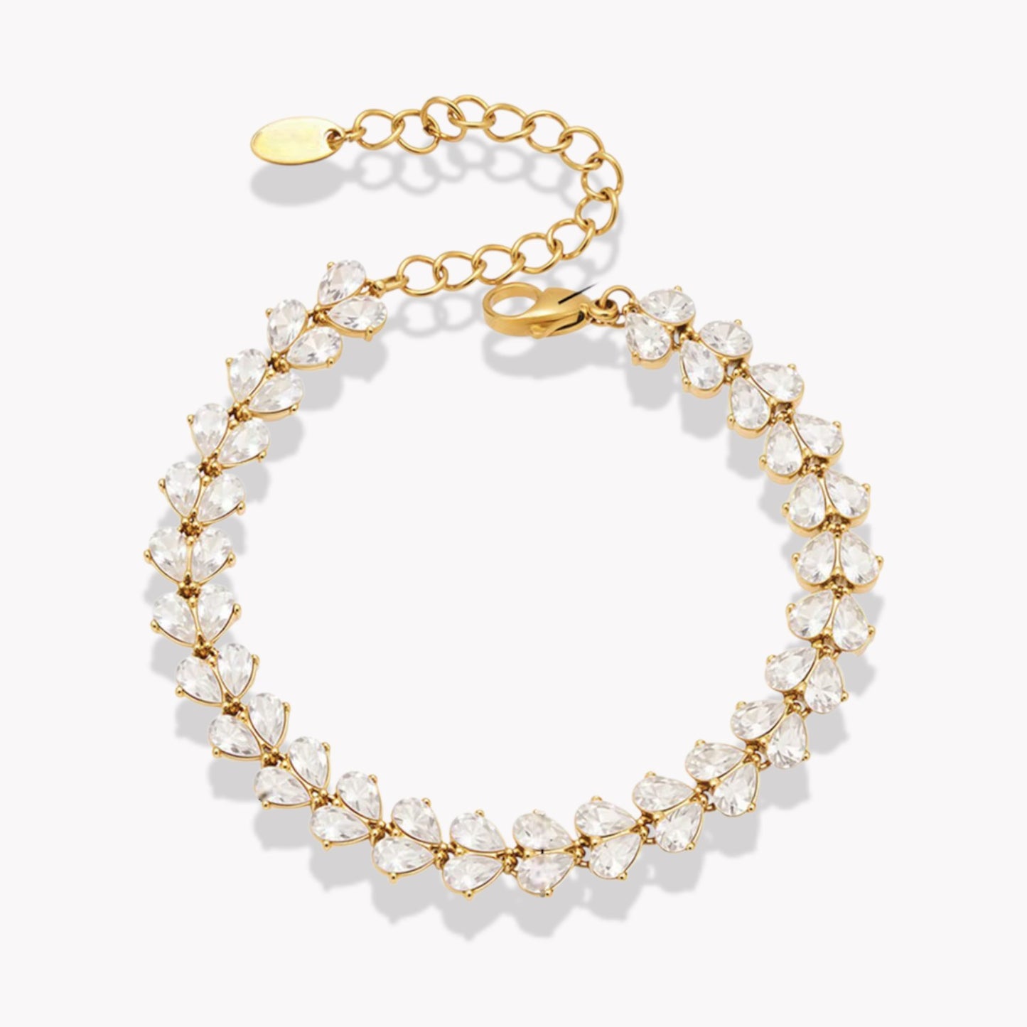 Gold bracelet with clear pear shaped gemstones on a white background