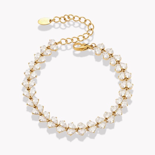 Gold bracelet with clear pear shaped gemstones on a white background