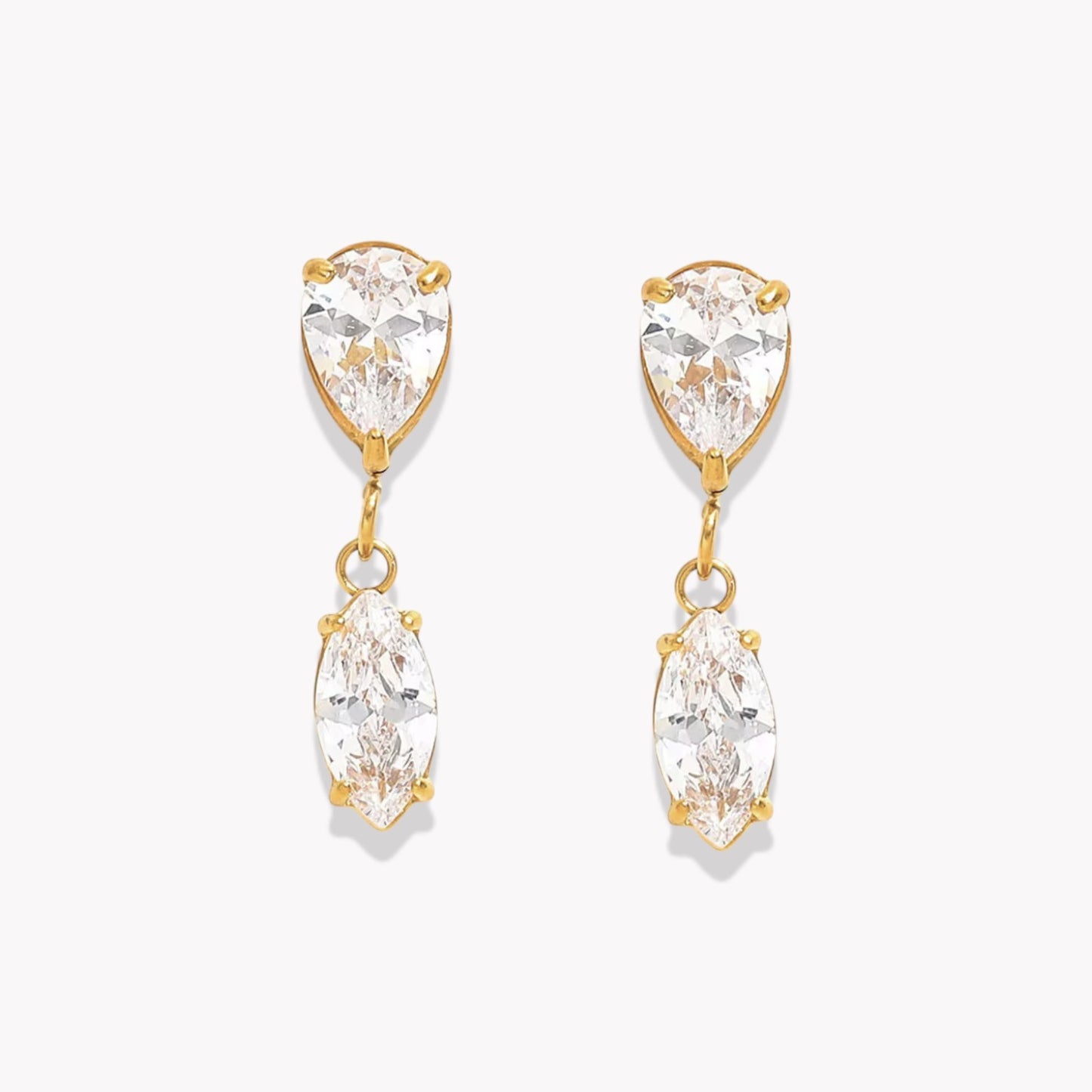 Gold earrings with clear gemstones on a white background