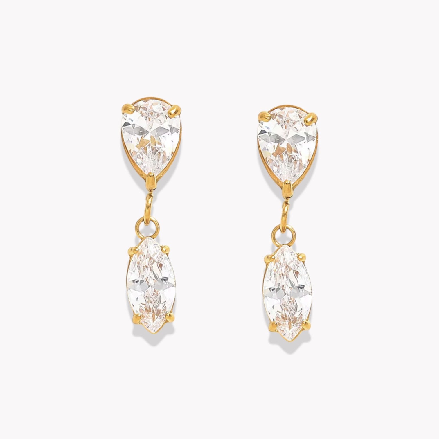 Gold earrings with clear gemstones on a white background