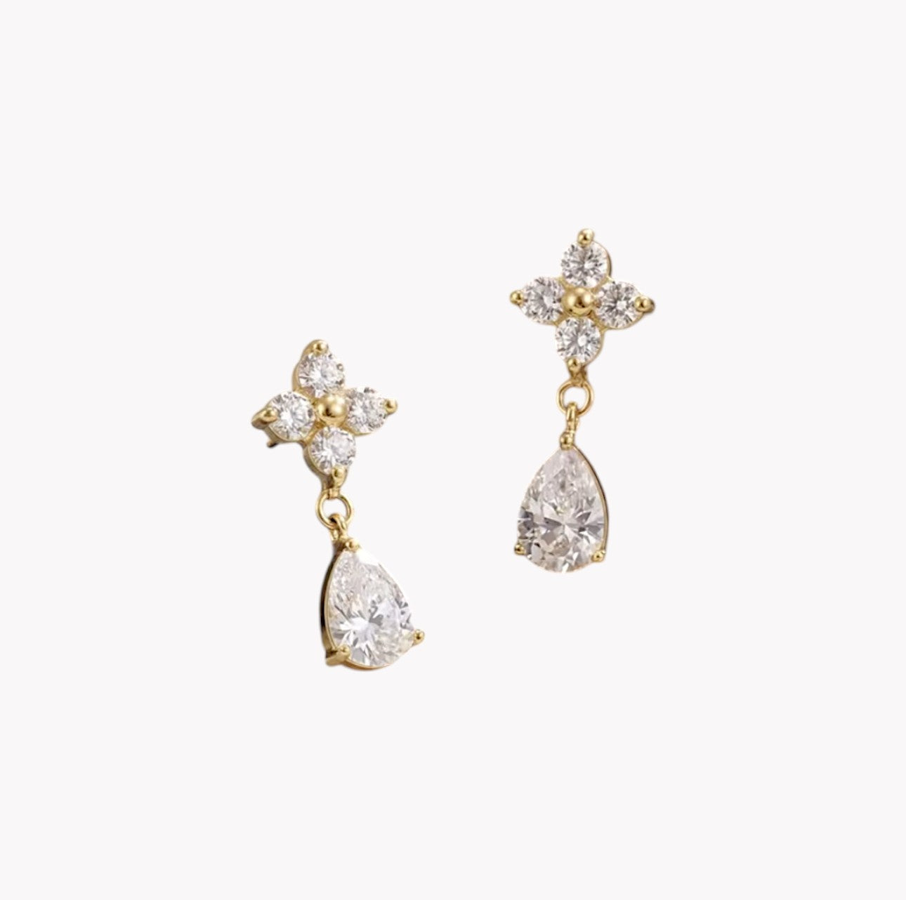 Gold earrings with teardrop-shaped crystals on a white background