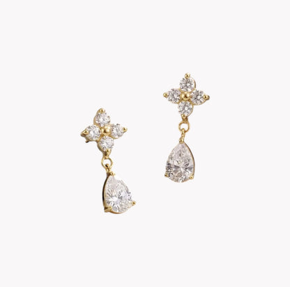Gold earrings with teardrop-shaped crystals on a white background