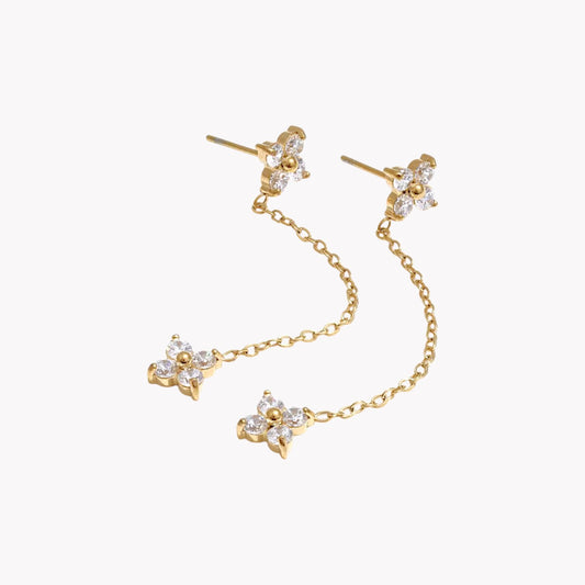 flower shapes gemstone on a long earring stud on a light grey background