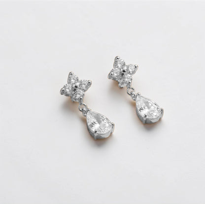 Pair of silver earrings with teardrop-shaped crystals on a white background