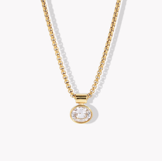 Necklace with gold chain and round crystal pendant on a white background