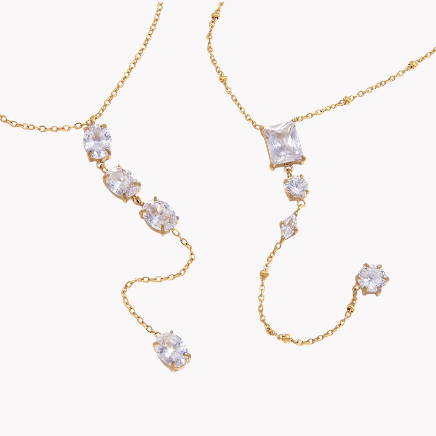gold necklace featuring clear gemstones of different shapes pictured on a light grey background
