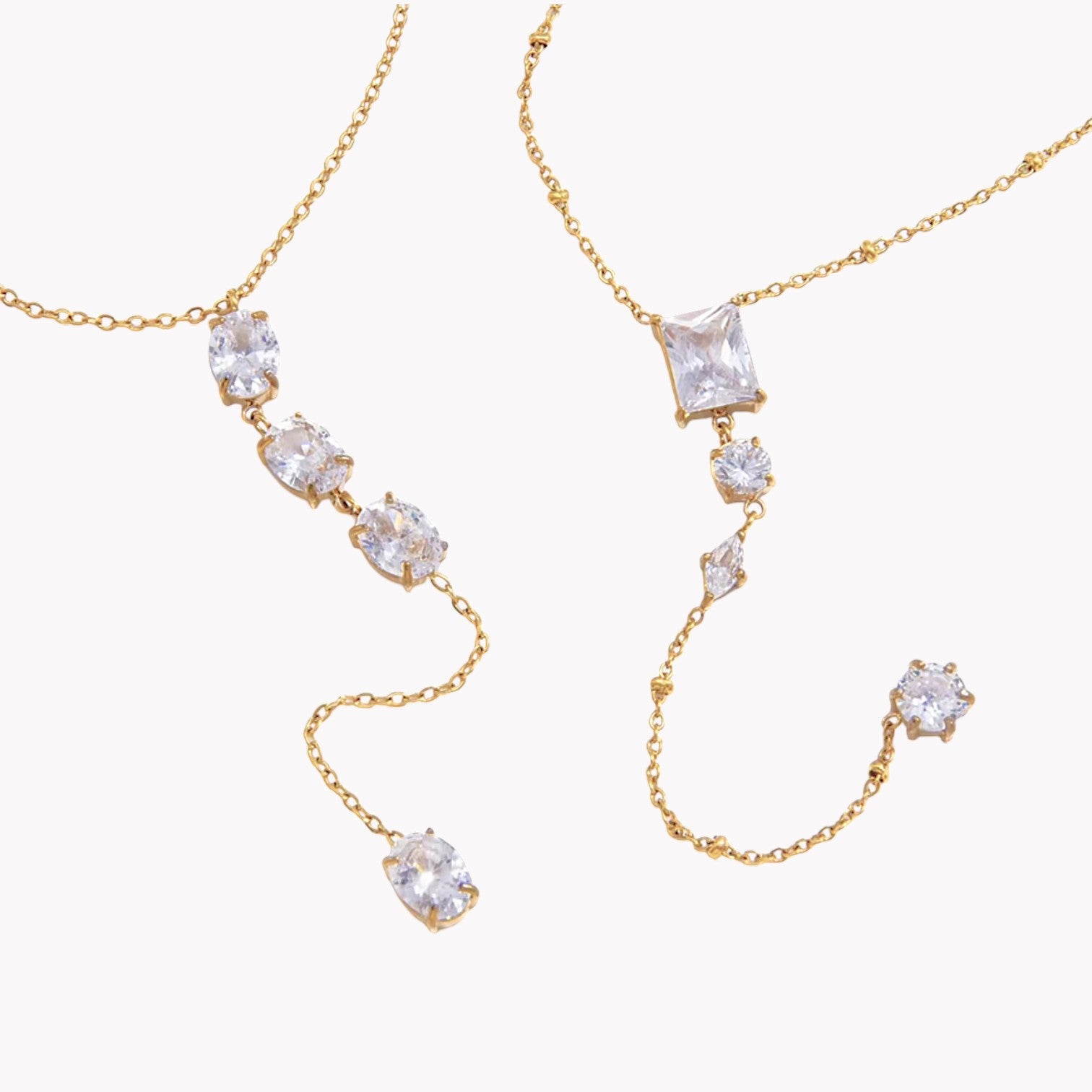 gold necklace featuring clear gemstones of different shapes pictured on a light grey background