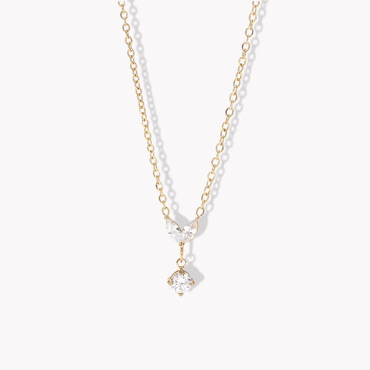Gold necklace with a clear marquise and round shaped pendant pictured on a white background