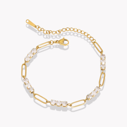 A gold-colored bracelet with link chains and adorned with white crystals, displayed against a white background.