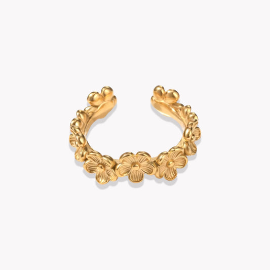 An adjustable gold ring with a floral pattern around the band, displayed against a white background.