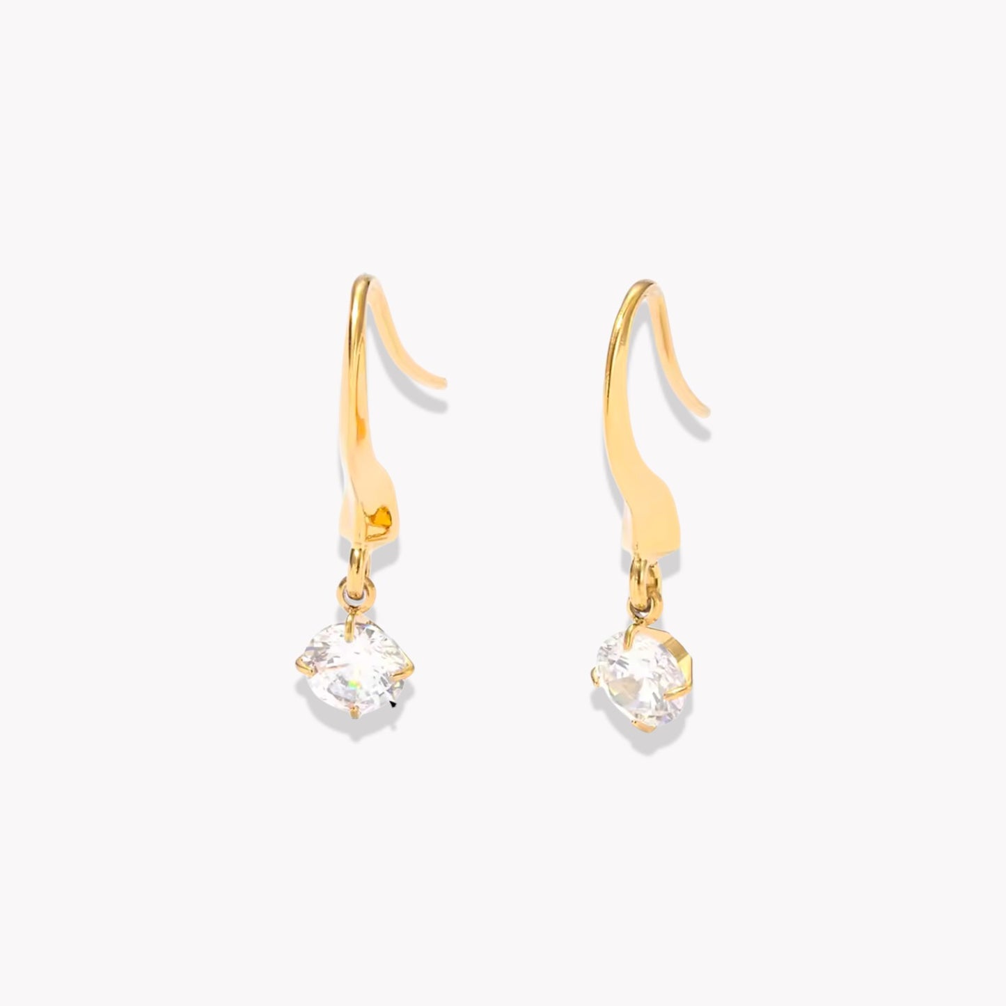 Gold earrings with clear gemstones on a white background